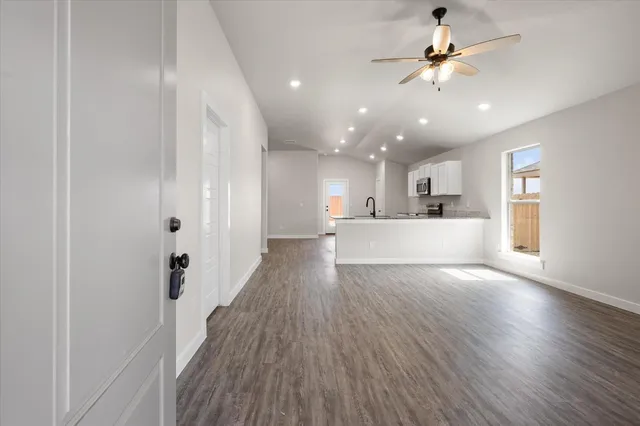 a view of a big room with wooden floor and windows