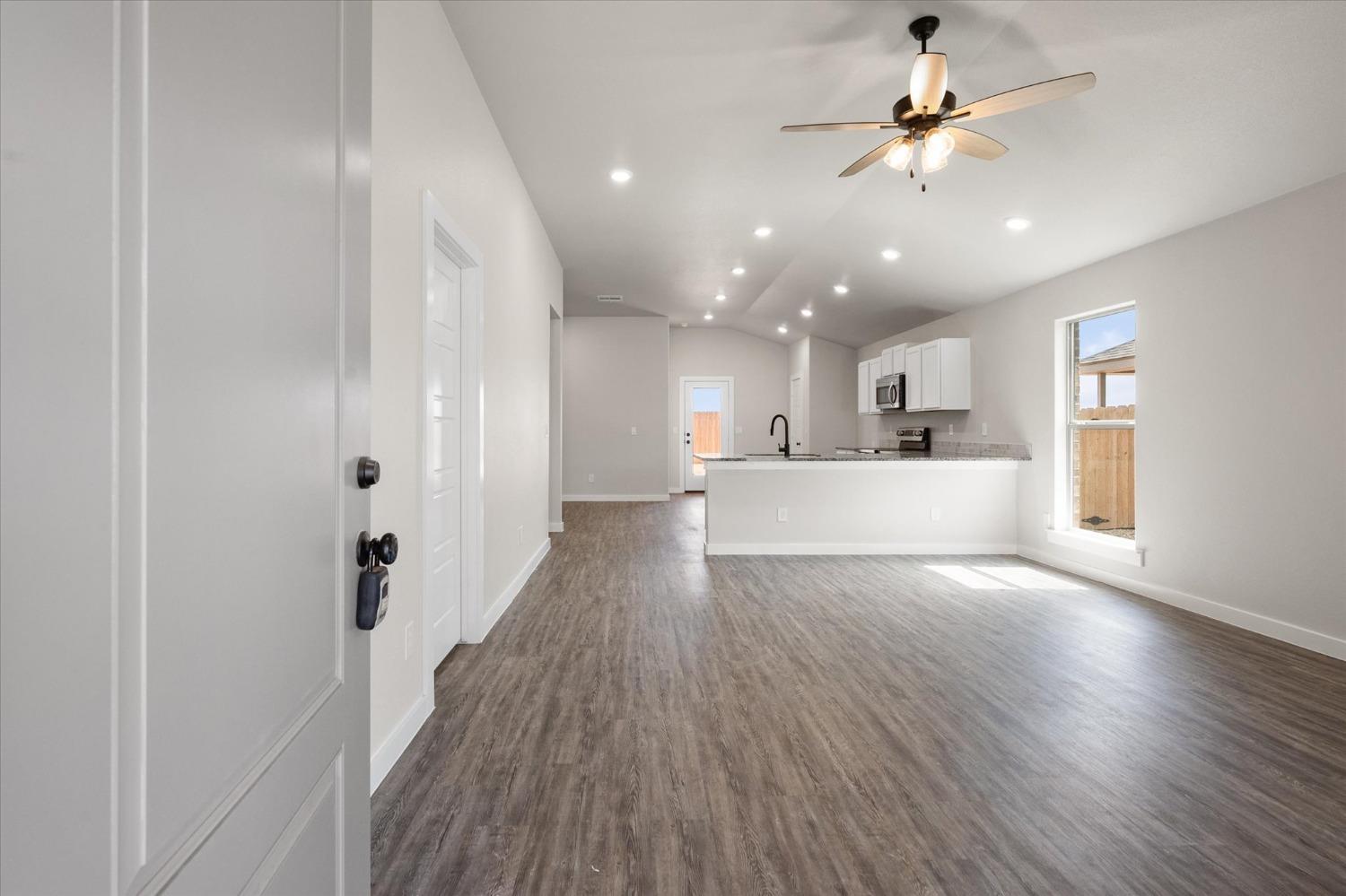 8622 26th Street Lubbock, TX 79407 - Photo 7 of 16 a view of a big room with wooden floor and windows