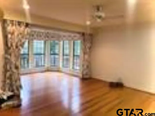 a view of room with floor to ceiling window and wooden floor