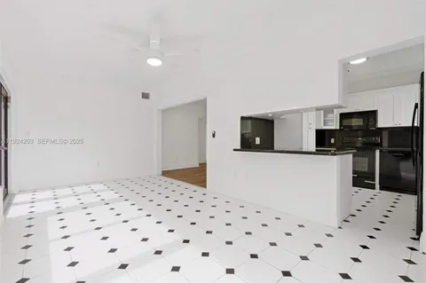a kitchen with granite countertop a refrigerator and a stove top oven