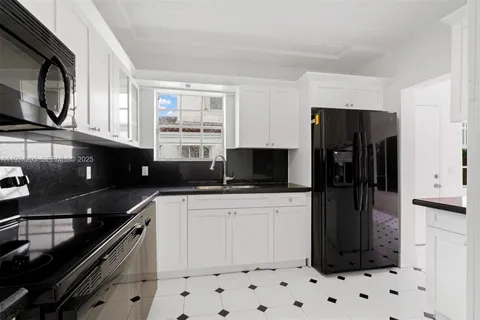 a kitchen with a sink a refrigerator and cabinets