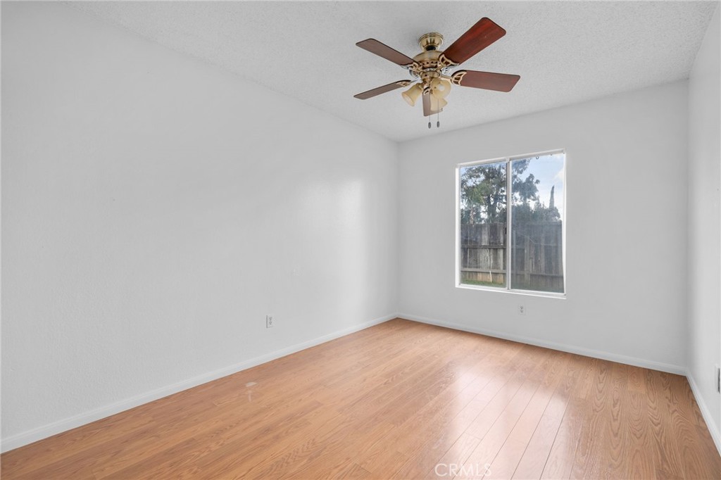 5423 Dunlop Drive Riverside, CA 92505 - Photo 23 of 28 an empty room with wooden floor and ceiling fan