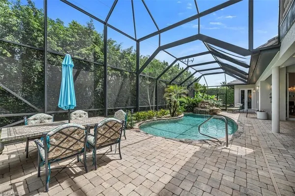 a view of backyard with swimming pool table and chairs