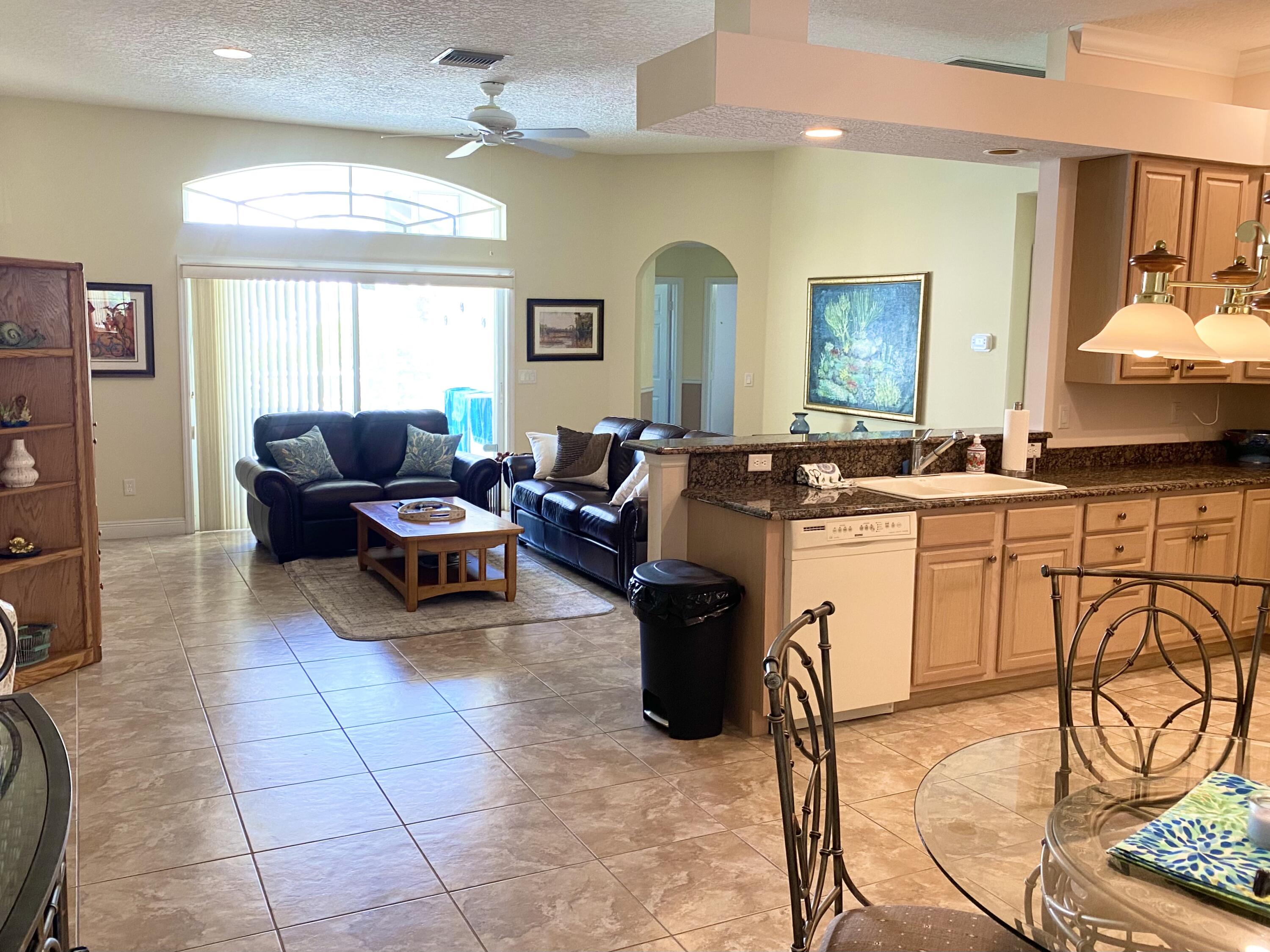 225 Clocktower Drive Jupiter, FL 33458 - Photo 12 of 40 a living room with furniture a flat screen tv and a window