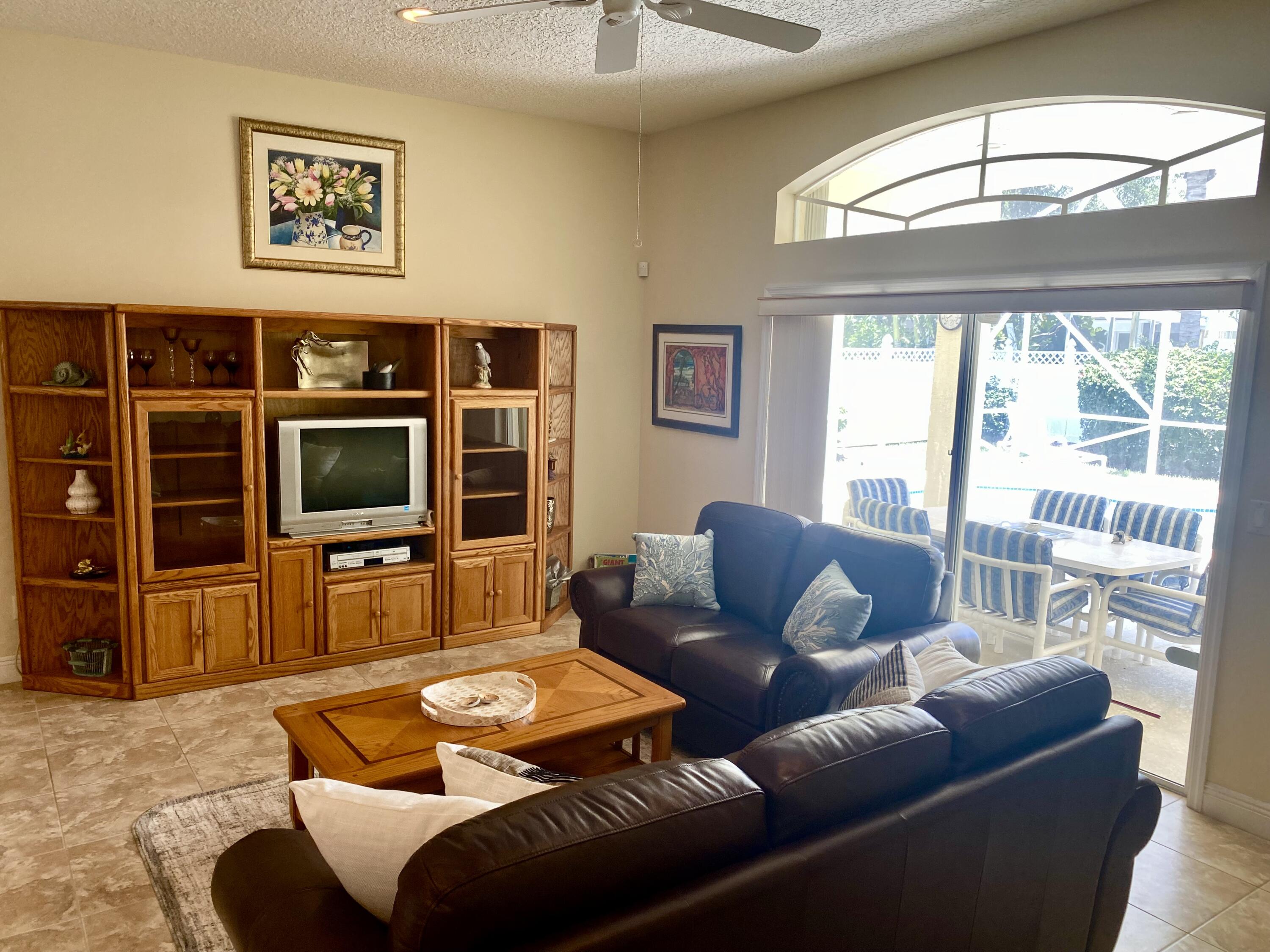 225 Clocktower Drive Jupiter, FL 33458 - Photo 14 of 40 a living room with furniture a flat screen tv and a large window