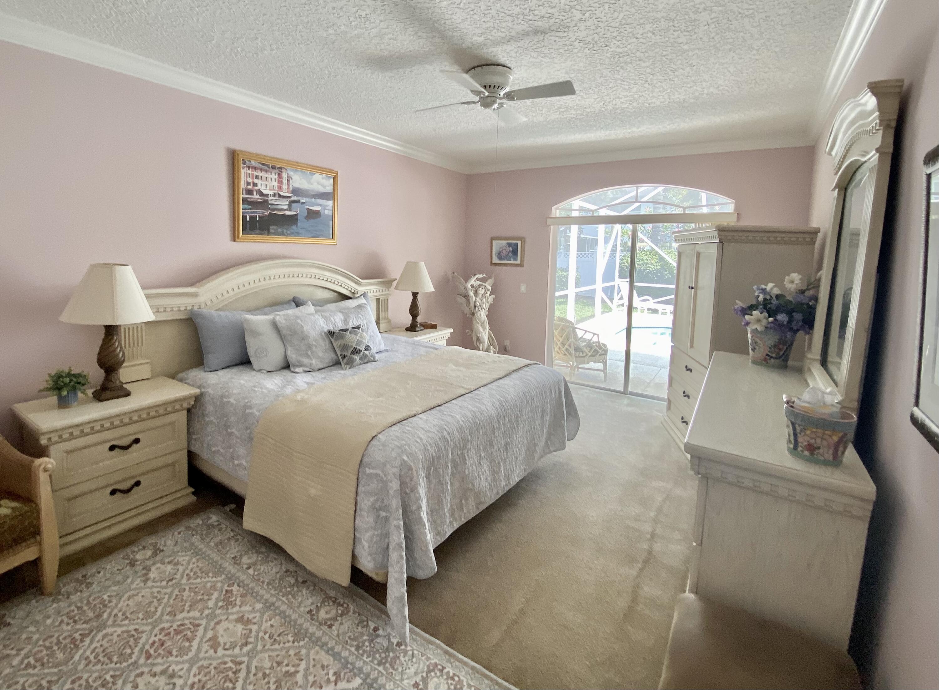 225 Clocktower Drive Jupiter, FL 33458 - Photo 15 of 40 a spacious bedroom with a bed and a large window