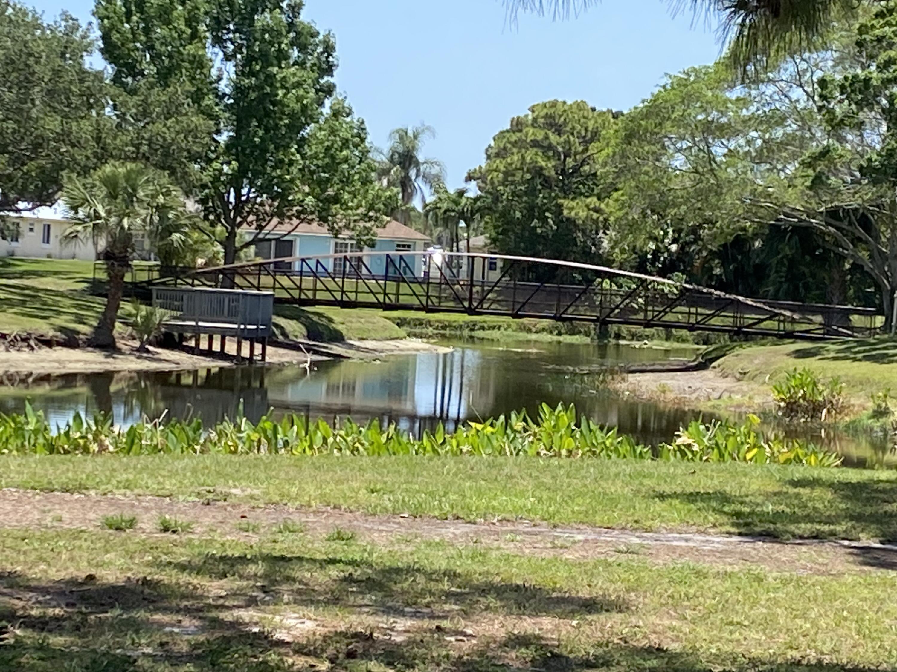 225 Clocktower Drive Jupiter, FL 33458 - Photo 31 of 40 a view of a lake with a house in the background