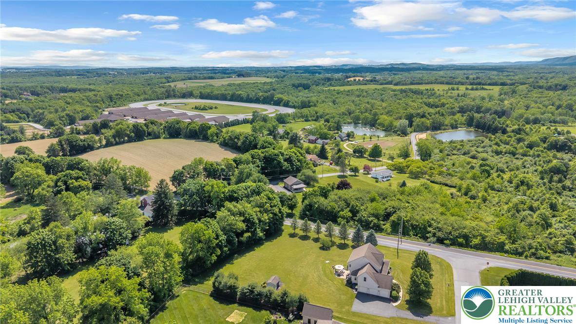 204 Bushkill Ridge Road Wind Gap, PA 18091 - Photo 44 of 48 An aerial perspective reveals a verdant landscape with homes nestled among mature trees and a distant track.