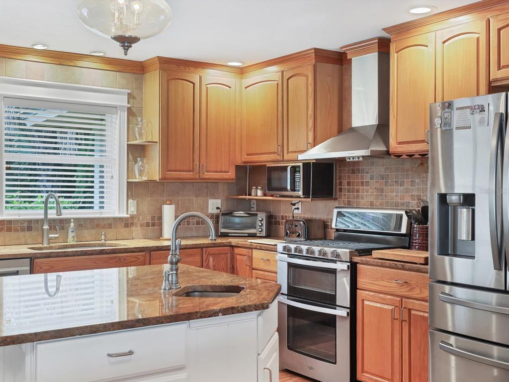 4708 Hidden River Road Sarasota, FL 34240 - Photo 18 of 67 a kitchen with stainless steel appliances granite countertop a sink stove and cabinets