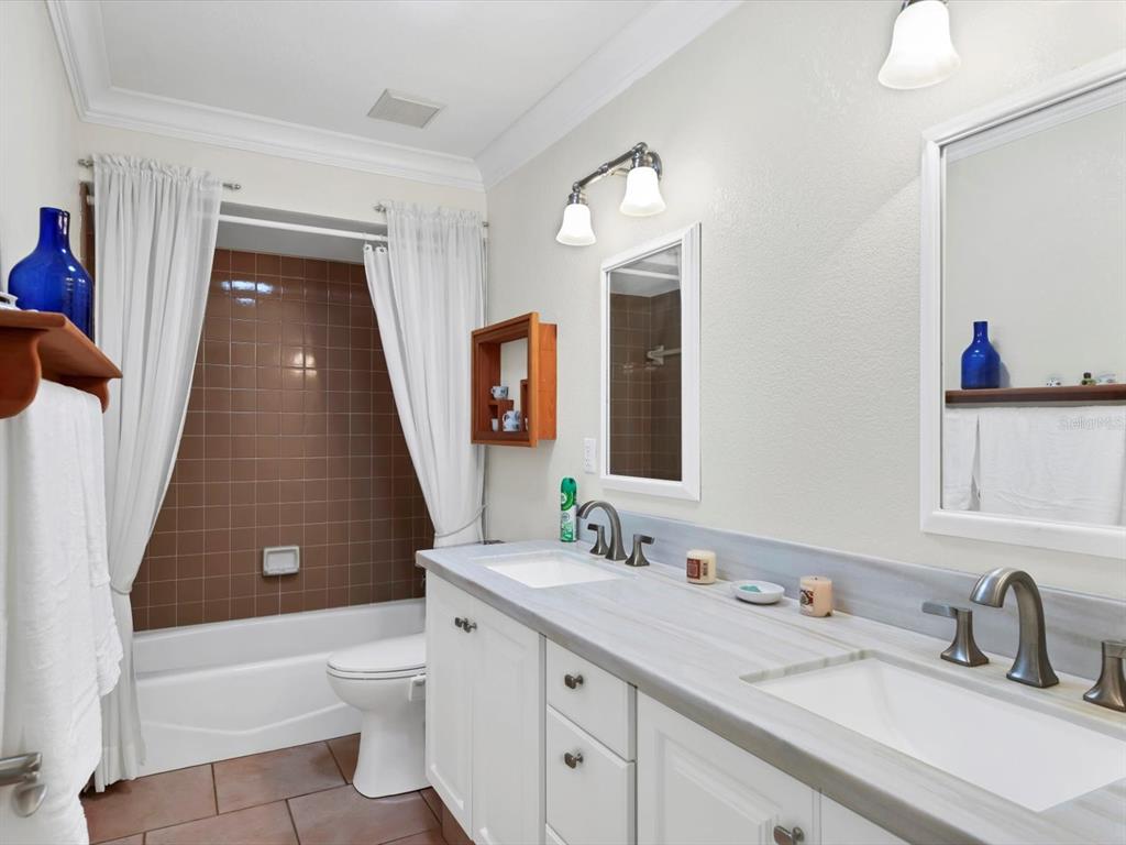 4708 Hidden River Road Sarasota, FL 34240 - Photo 27 of 67 a bathroom with a sink a toilet and a mirror