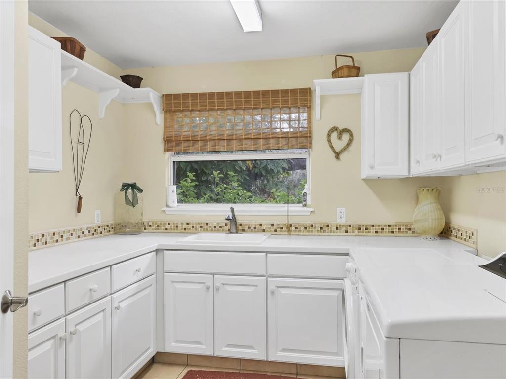 4708 Hidden River Road Sarasota, FL 34240 - Photo 28 of 67 a kitchen with white cabinets and a window