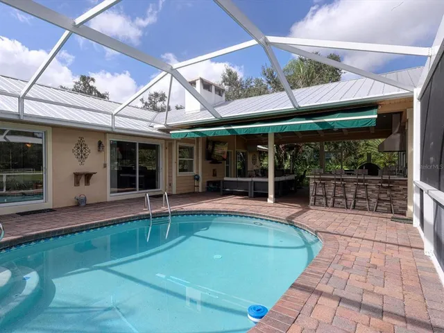 a view of a swimming pool with a lawn chairs under an umbrella