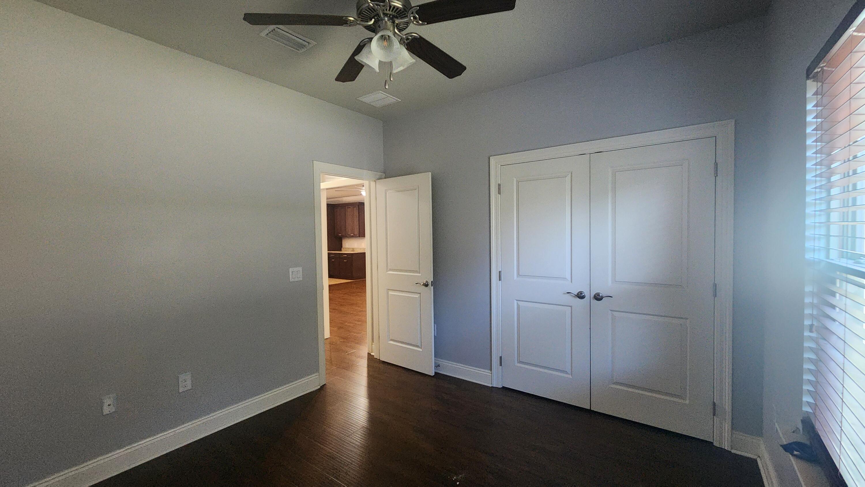 2133 Janet Street Navarre, FL 32566 - Photo 6 of 14 an empty room with wooden floor closet and windows