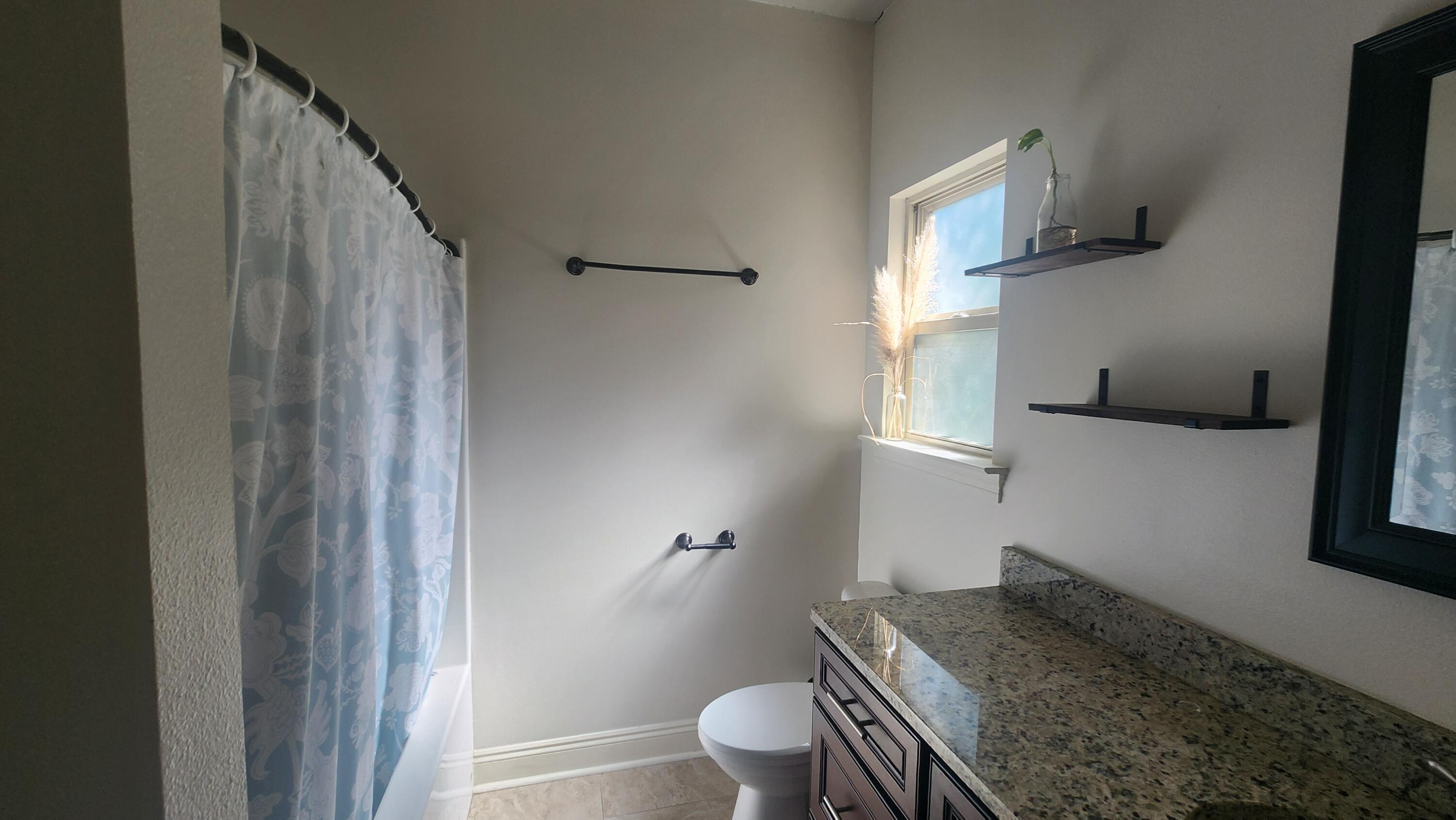 2133 Janet Street Navarre, FL 32566 - Photo 8 of 14 a bathroom with a granite countertop sink toilet and a mirror