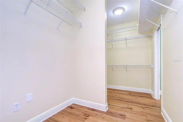 a view of an empty walk in closet with wooden floor
