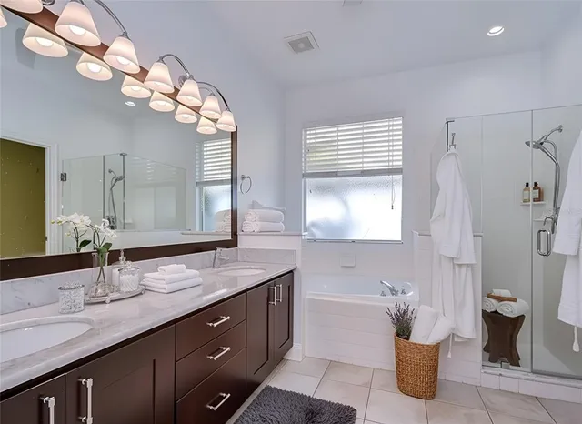 a bathroom with a granite countertop sink a large mirror and a shower