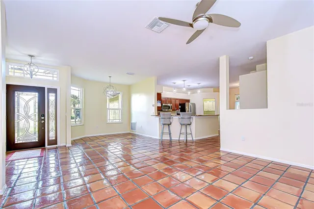 a view of a livingroom with furniture a ceiling fan and window