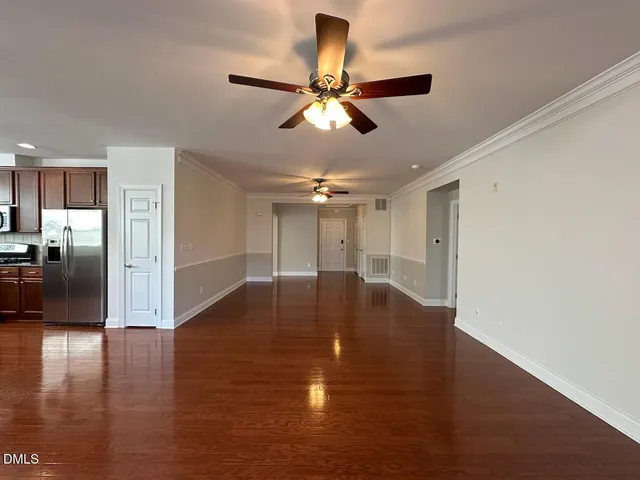 a view of empty room with wooden floor