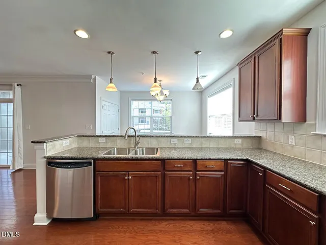 a kitchen with stainless steel appliances granite countertop a sink a stove and a refrigerator