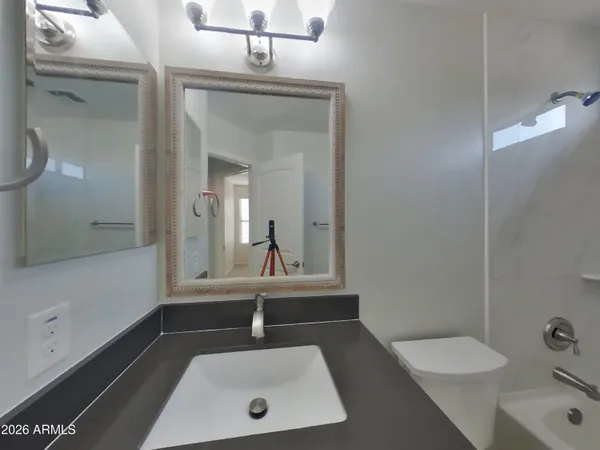 a bathroom with a sink a toilet and mirror