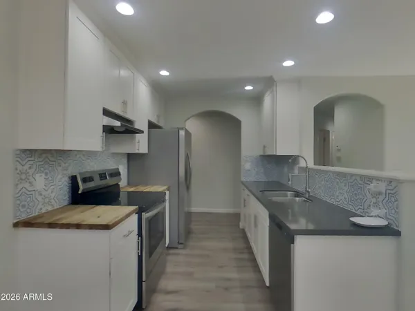 a kitchen with stainless steel appliances granite countertop a sink a stove and a refrigerator