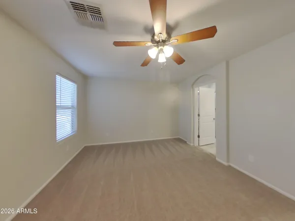 an empty room with windows and fan