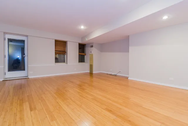 a view of an empty room with wooden floor