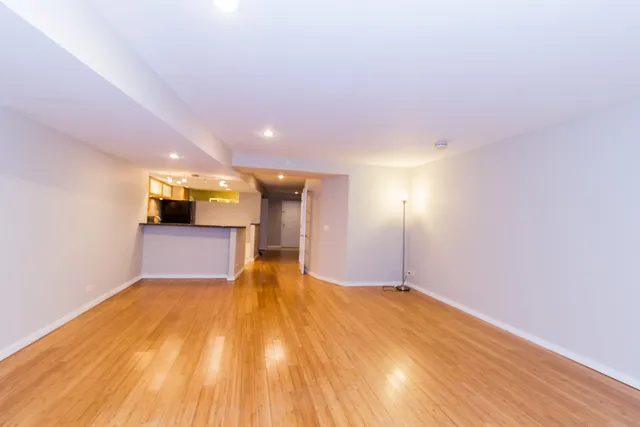 a view of empty room with wooden floor