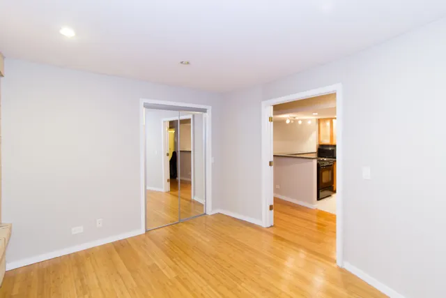 a view of empty room with wooden floor