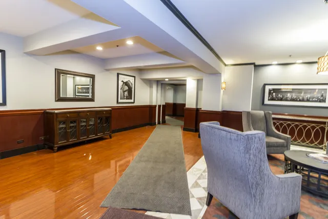 a view of a hallway with wooden floor and chandelier