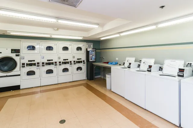 a view of kitchen with stainless steel appliances granite countertop a stove and a refrigerator