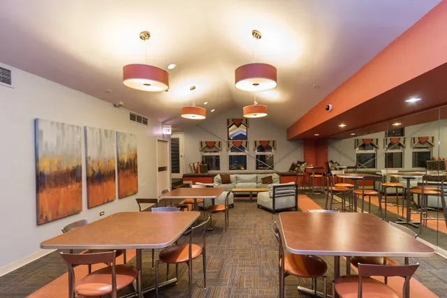 a living room with stainless steel appliances kitchen island a table and chairs in it