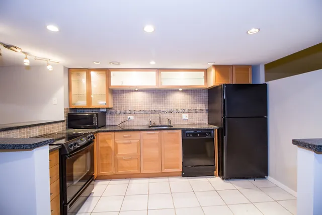 a kitchen with stainless steel appliances granite countertop a refrigerator and a stove
