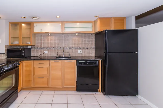 a kitchen with stainless steel appliances granite countertop a refrigerator a sink and a stove