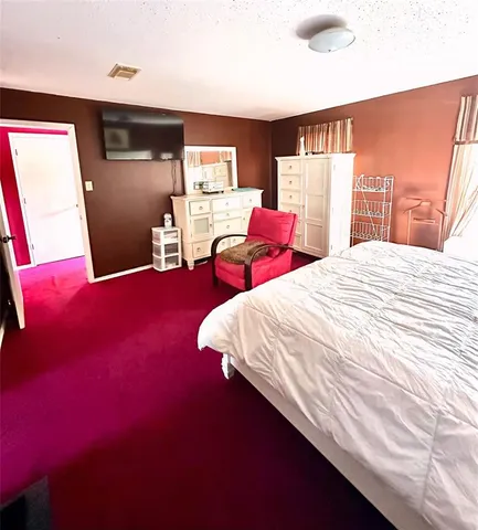 a bed sitting in a bedroom next to a window with bookshelf