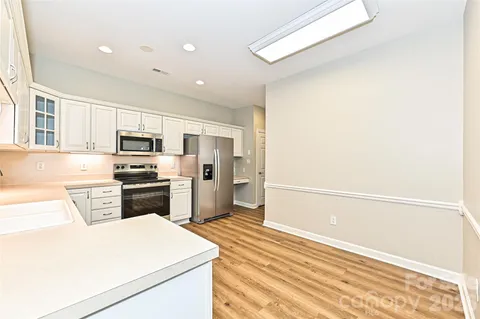 a kitchen with stainless steel appliances a refrigerator and a stove top oven