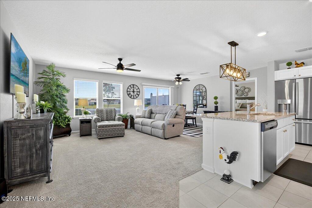 7 Windsor Place Palm Coast, FL 32164 - Photo 11 of 40 a living room with furniture and a chandelier