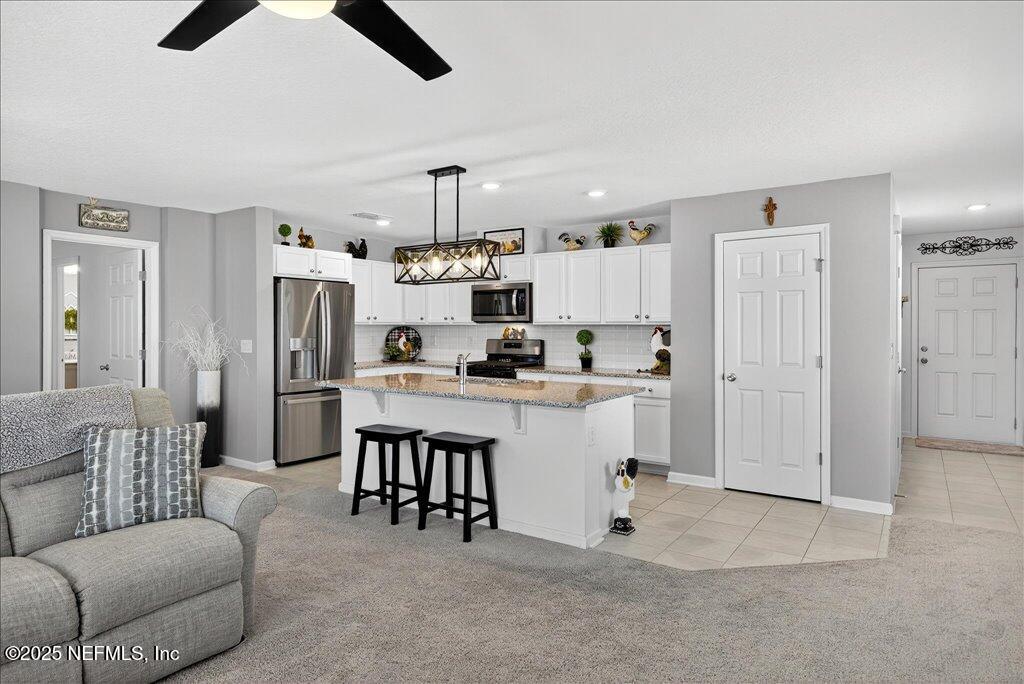 7 Windsor Place Palm Coast, FL 32164 - Photo 14 of 40 a kitchen with white cabinets and stainless steel appliances