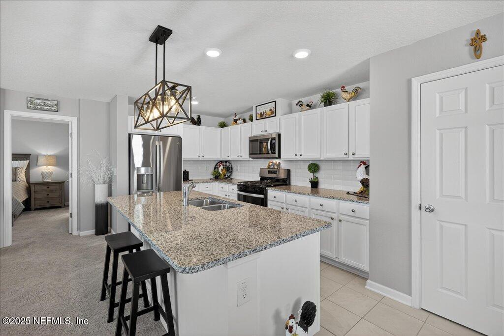 7 Windsor Place Palm Coast, FL 32164 - Photo 15 of 40 a kitchen with granite countertop white cabinets and stainless steel appliances