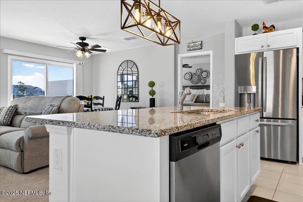 7 Windsor Place Palm Coast, FL 32164 - Photo 17 of 40 a kitchen with stainless steel appliances granite countertop a sink and a refrigerator