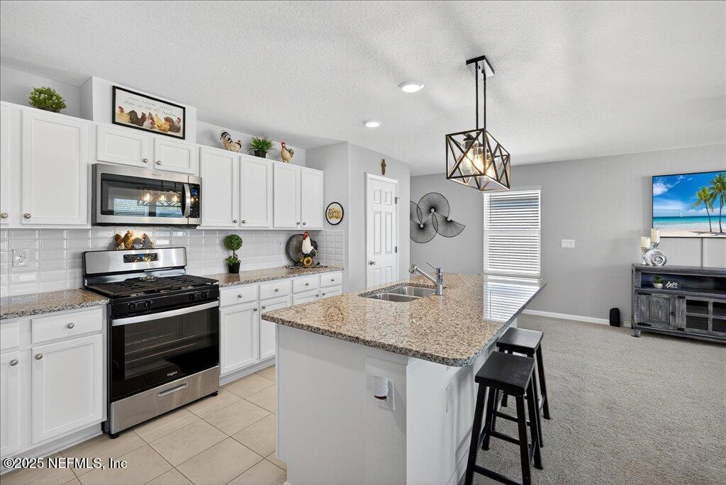 7 Windsor Place Palm Coast, FL 32164 - Photo 20 of 40 a kitchen with granite countertop a sink cabinets and stainless steel appliances