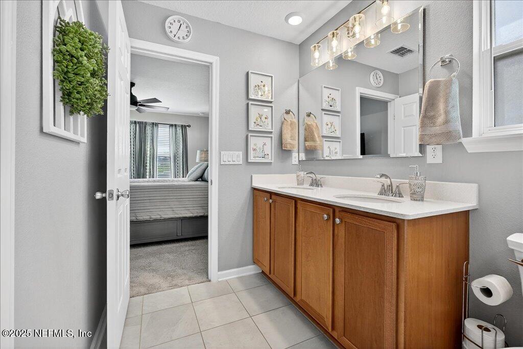 7 Windsor Place Palm Coast, FL 32164 - Photo 30 of 40 a en suite bathroom with a double vanity sink a mirror and a bathtub