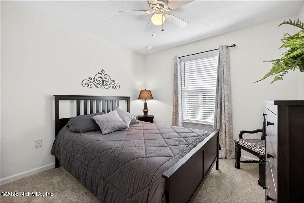 7 Windsor Place Palm Coast, FL 32164 - Photo 32 of 40 a bedroom with a bed and a chandelier