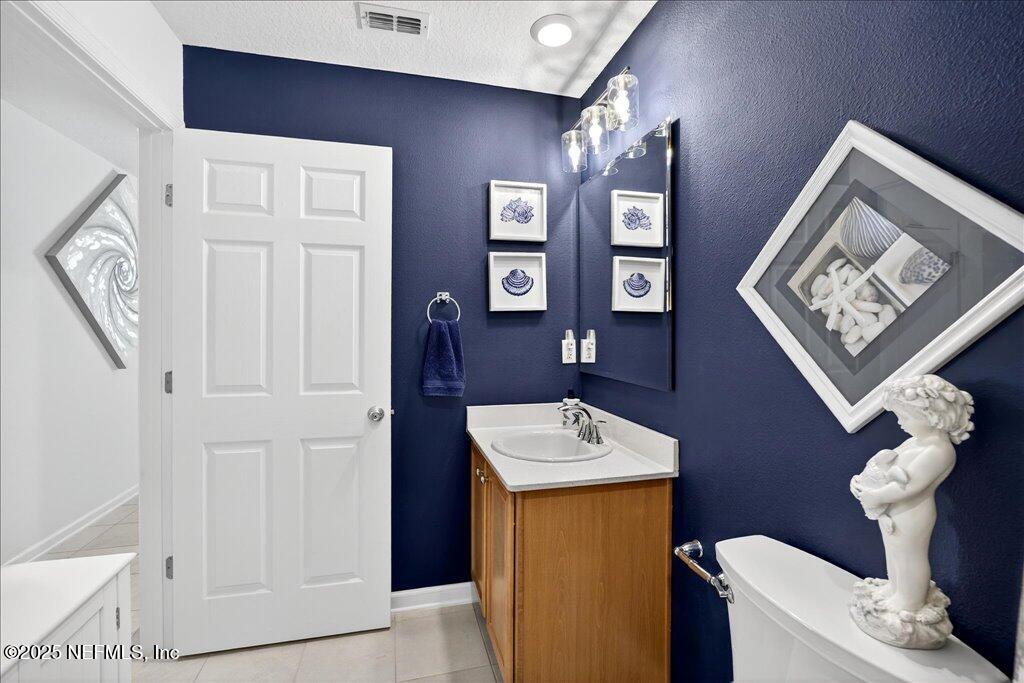 7 Windsor Place Palm Coast, FL 32164 - Photo 35 of 40 a bathroom with a toilet a sink and mirror