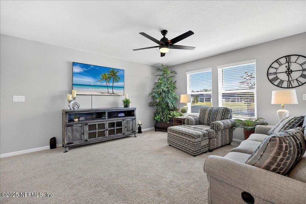 7 Windsor Place Palm Coast, FL 32164 - Photo 10 of 40 a living room with furniture a ceiling fan and a window