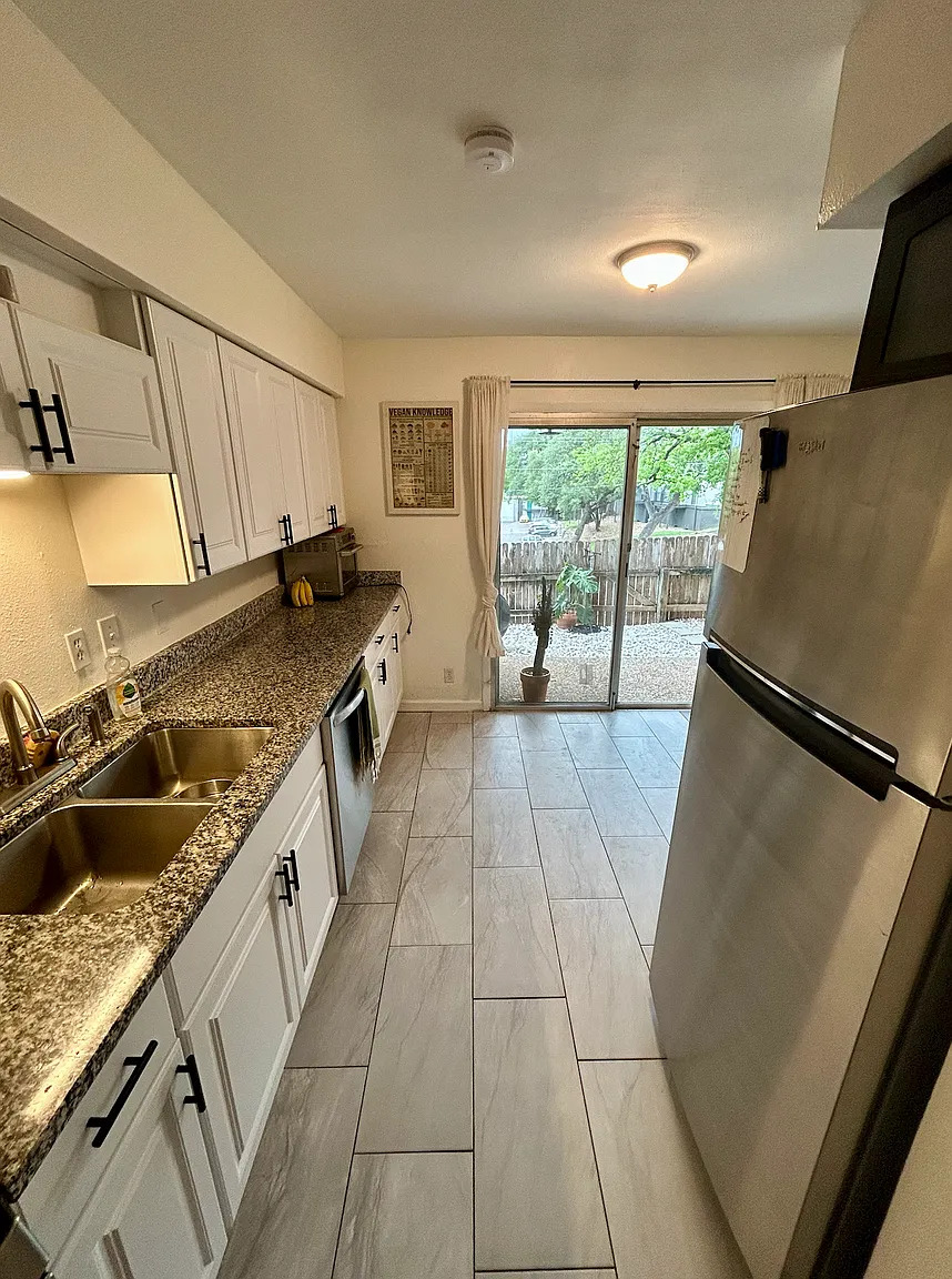 620 South 1st Street, Unit 106 Austin, TX 78704 - Photo 5 of 13 a kitchen with a sink a stove and a refrigerator