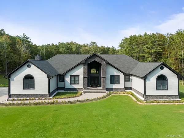 a front view of a house with a garden and yard