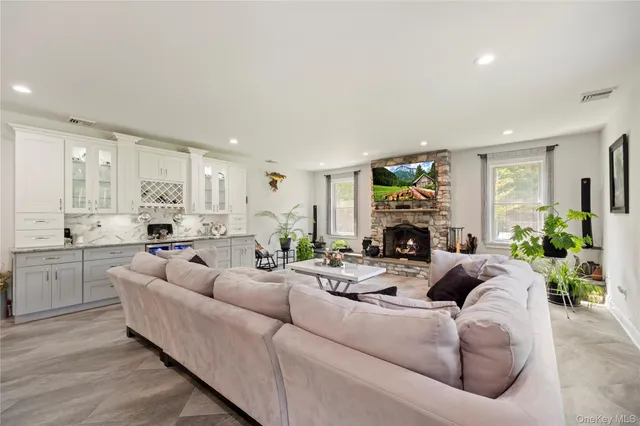 a living room with furniture a fireplace and a open kitchen view