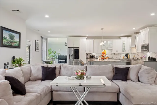 a living room with furniture kitchen view and a potted plant