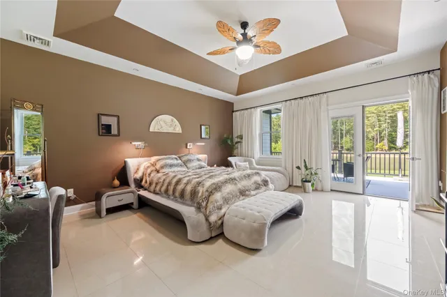 a spacious bedroom with a bed couch and a large window